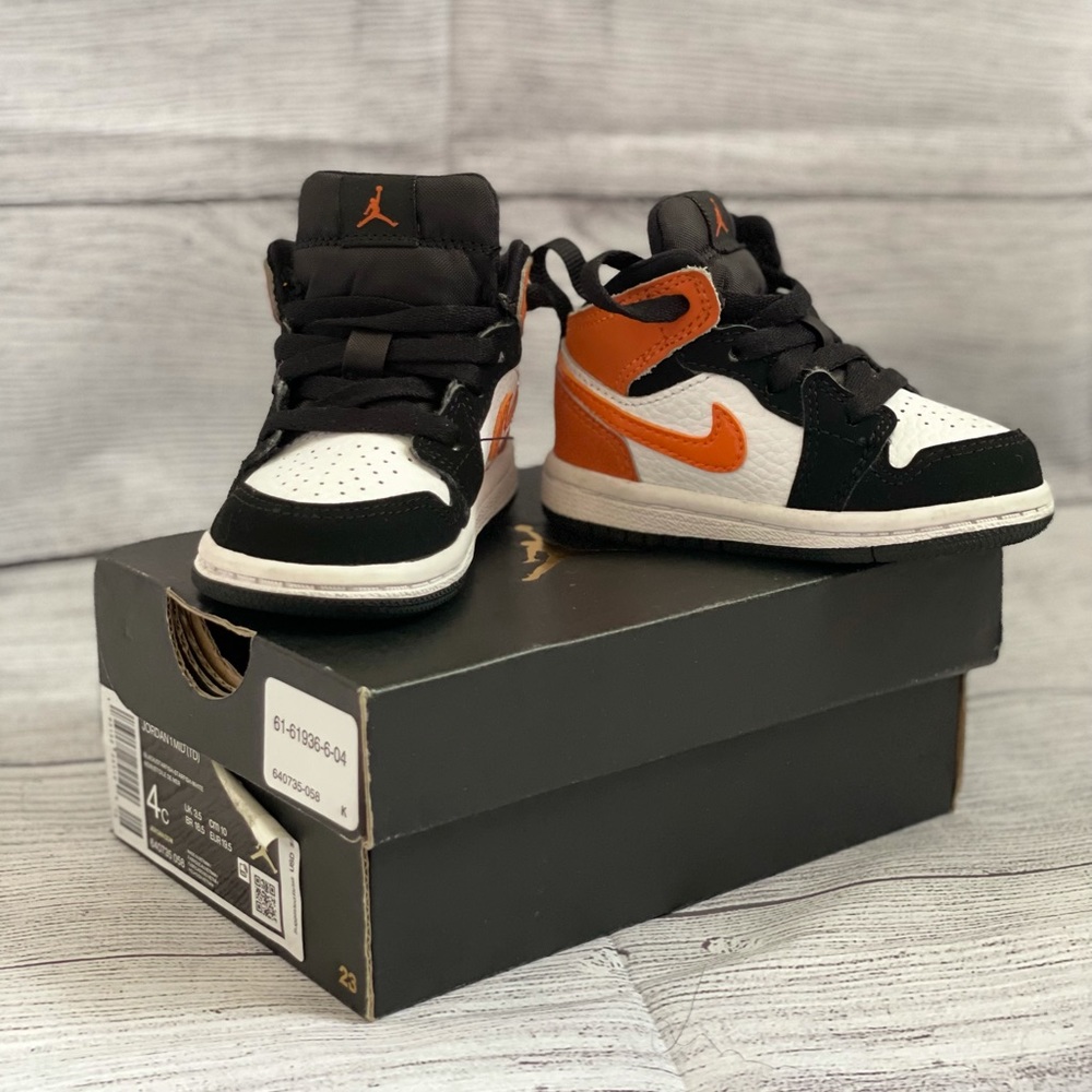 Retro Jordan 1s in orange and black, size 4C.